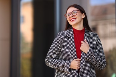 Photo of Beautiful woman in stylish suit outdoors. Space for text