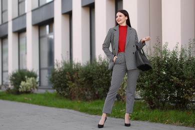 Beautiful woman in stylish suit outdoors. Space for text