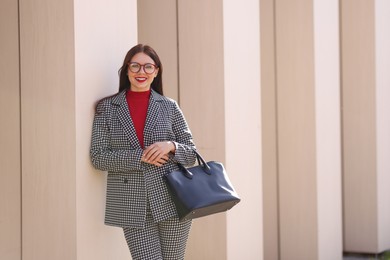 Photo of Smiling businesswoman in stylish suit outdoors on sunny day. Space for text