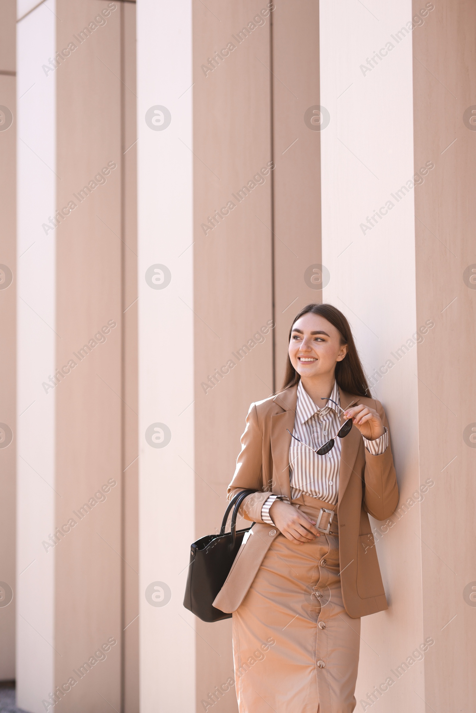 Photo of Beautiful woman in stylish suit outdoors. Space for text