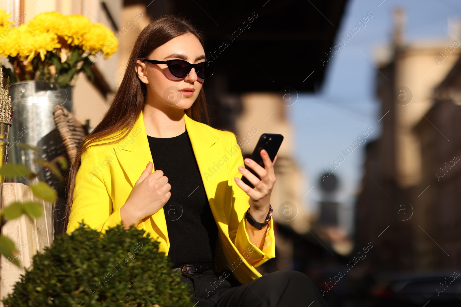 Photo of Businesswoman in stylish suit with smartphone outdoors on sunny day