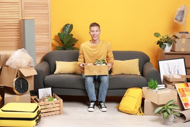 Happy man with different stuff in new apartment. Housewarming party