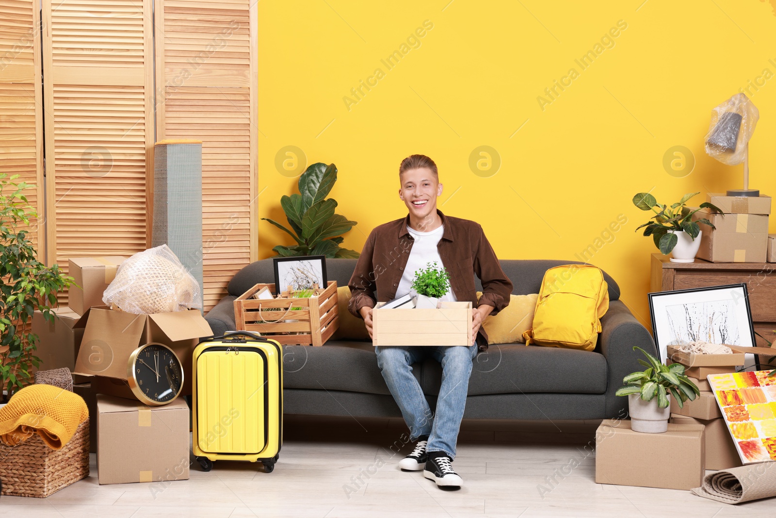 Photo of Happy man with different stuff in new apartment. Housewarming party