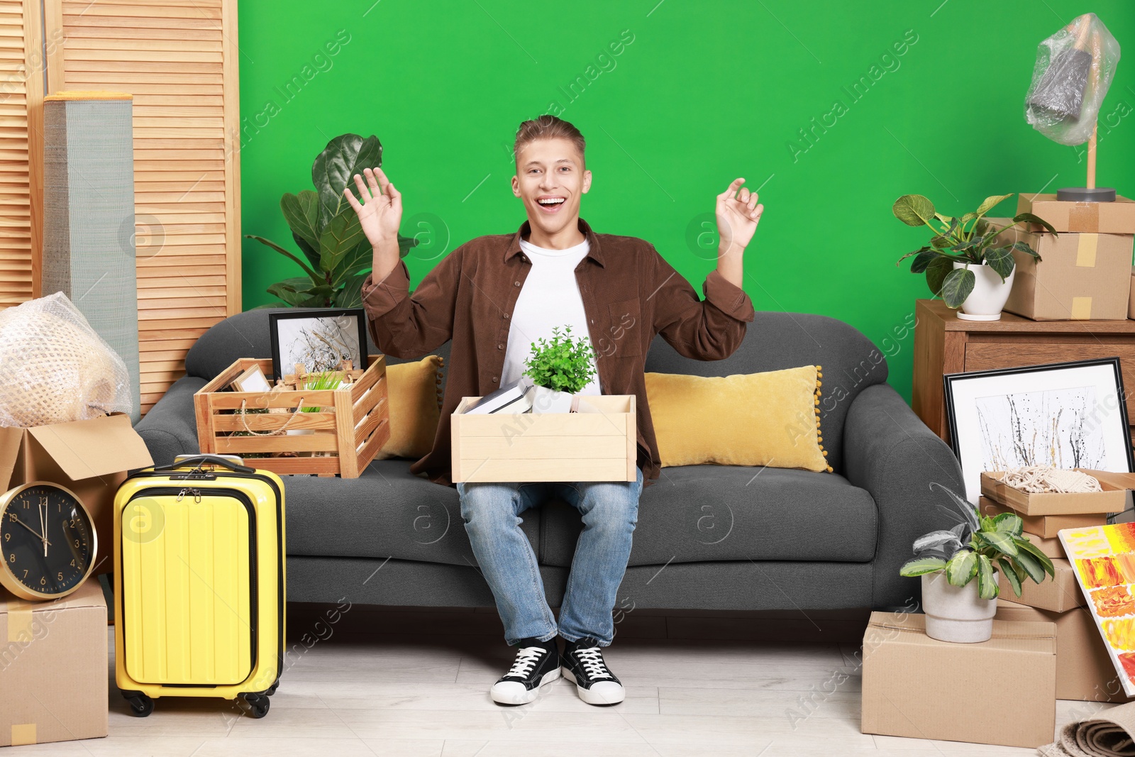 Photo of Happy man with different stuff in new apartment. Housewarming party