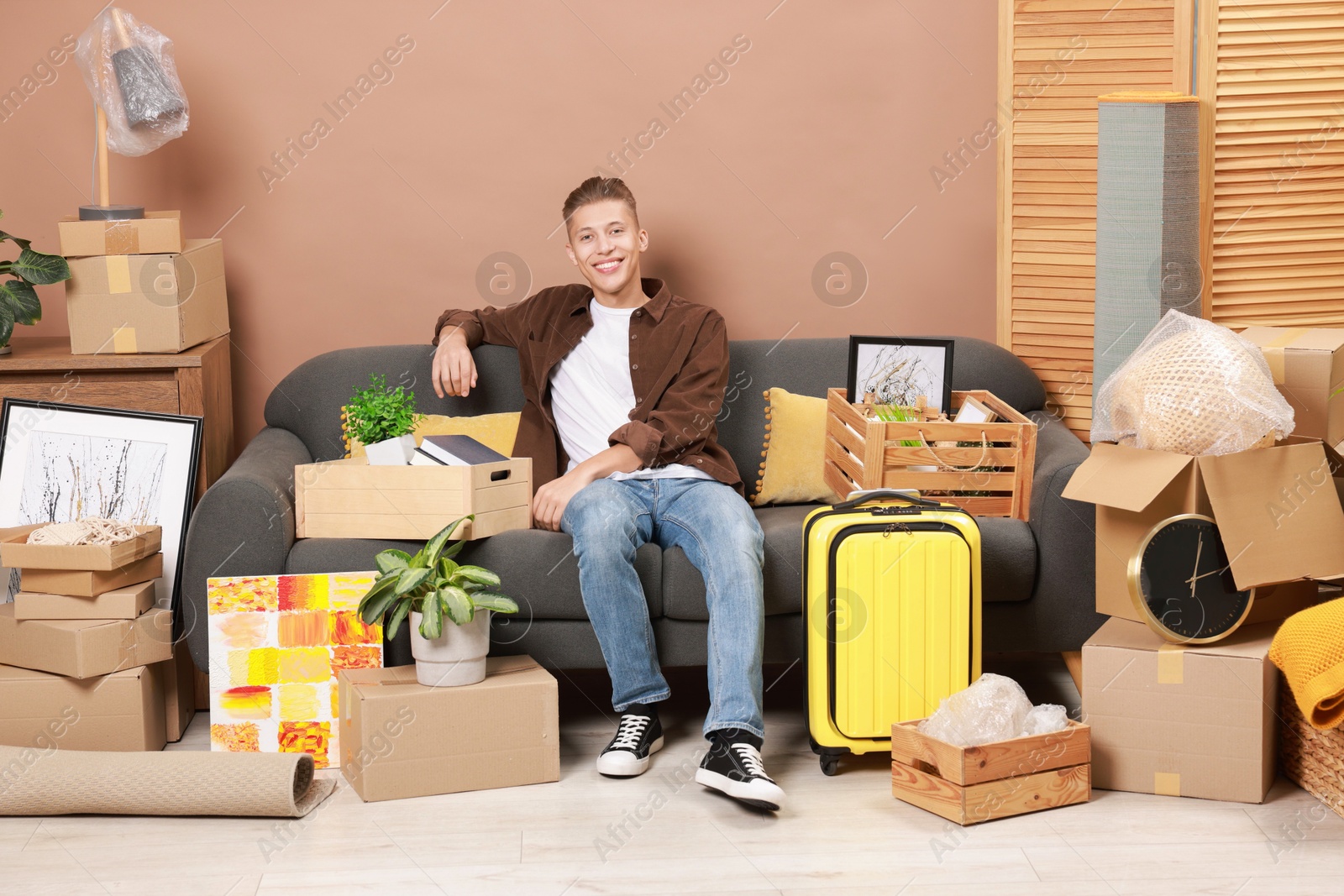 Photo of Happy man with different stuff in new apartment. Housewarming party