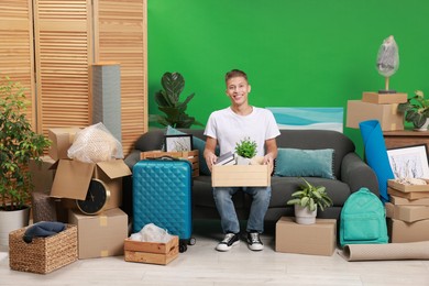 Photo of Happy man with different stuff in new apartment. Housewarming party