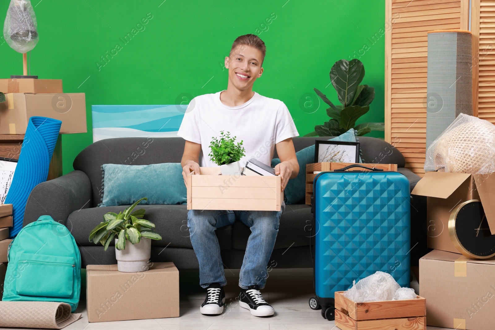 Photo of Happy man with different stuff in new apartment. Housewarming party