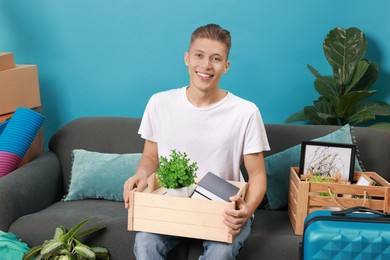 Photo of Happy man with different stuff in new apartment. Housewarming party