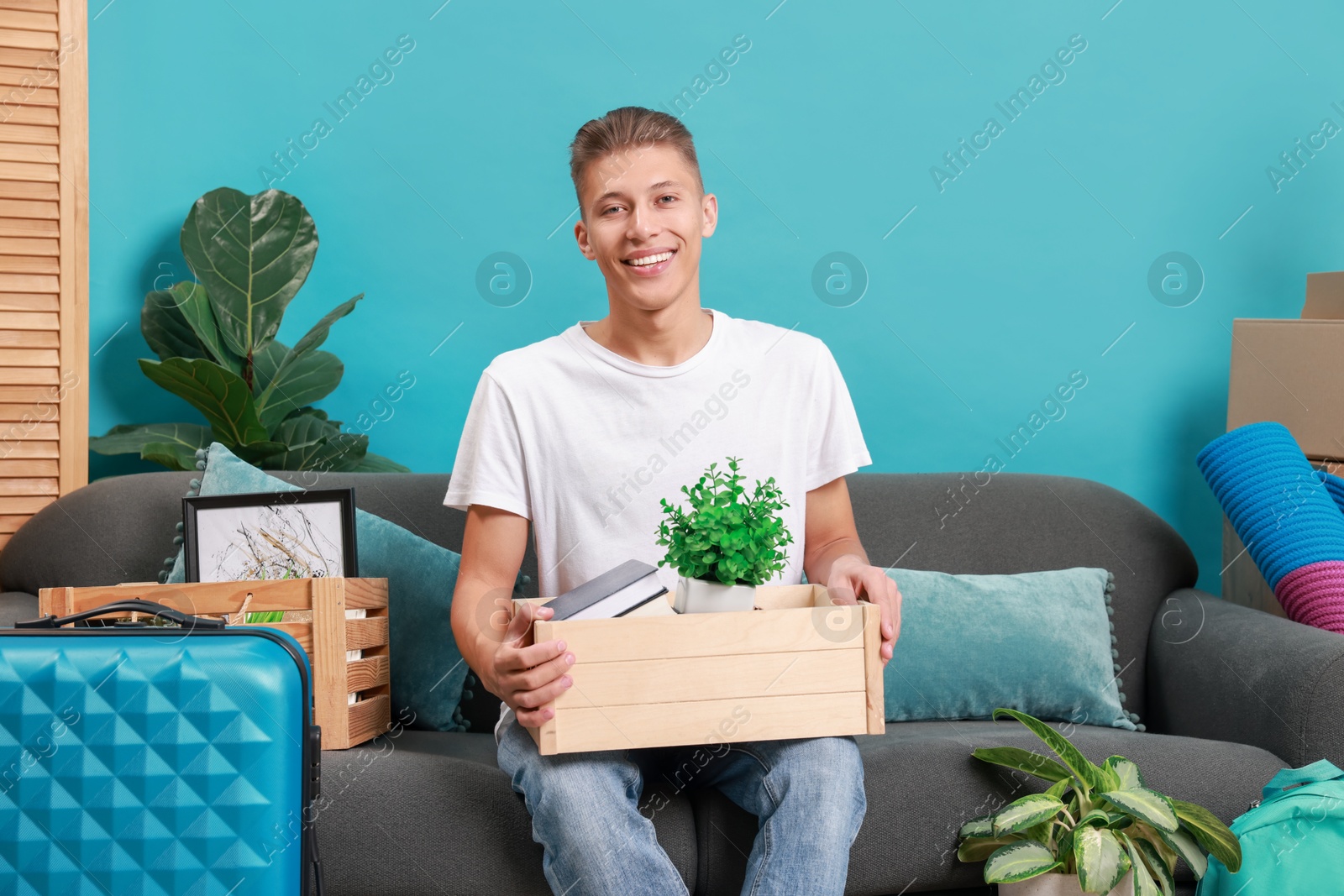 Photo of Happy man with different stuff in new apartment. Housewarming party