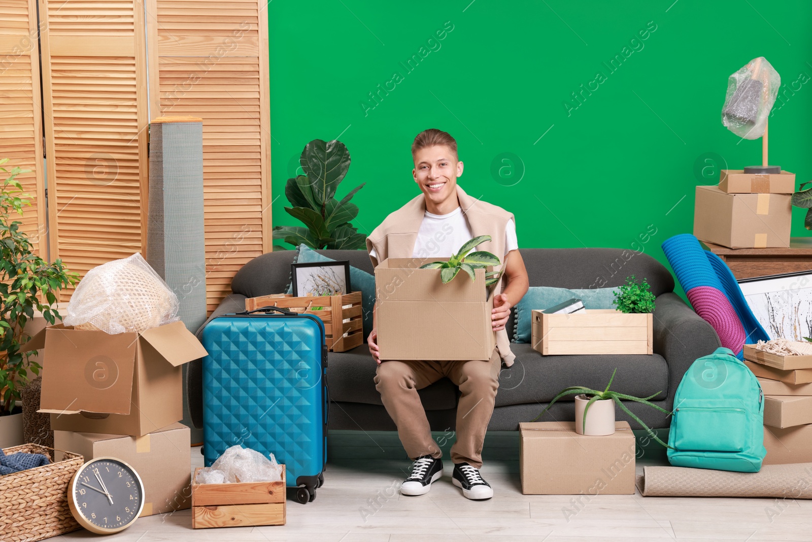 Photo of Happy man with different stuff in new apartment. Housewarming party