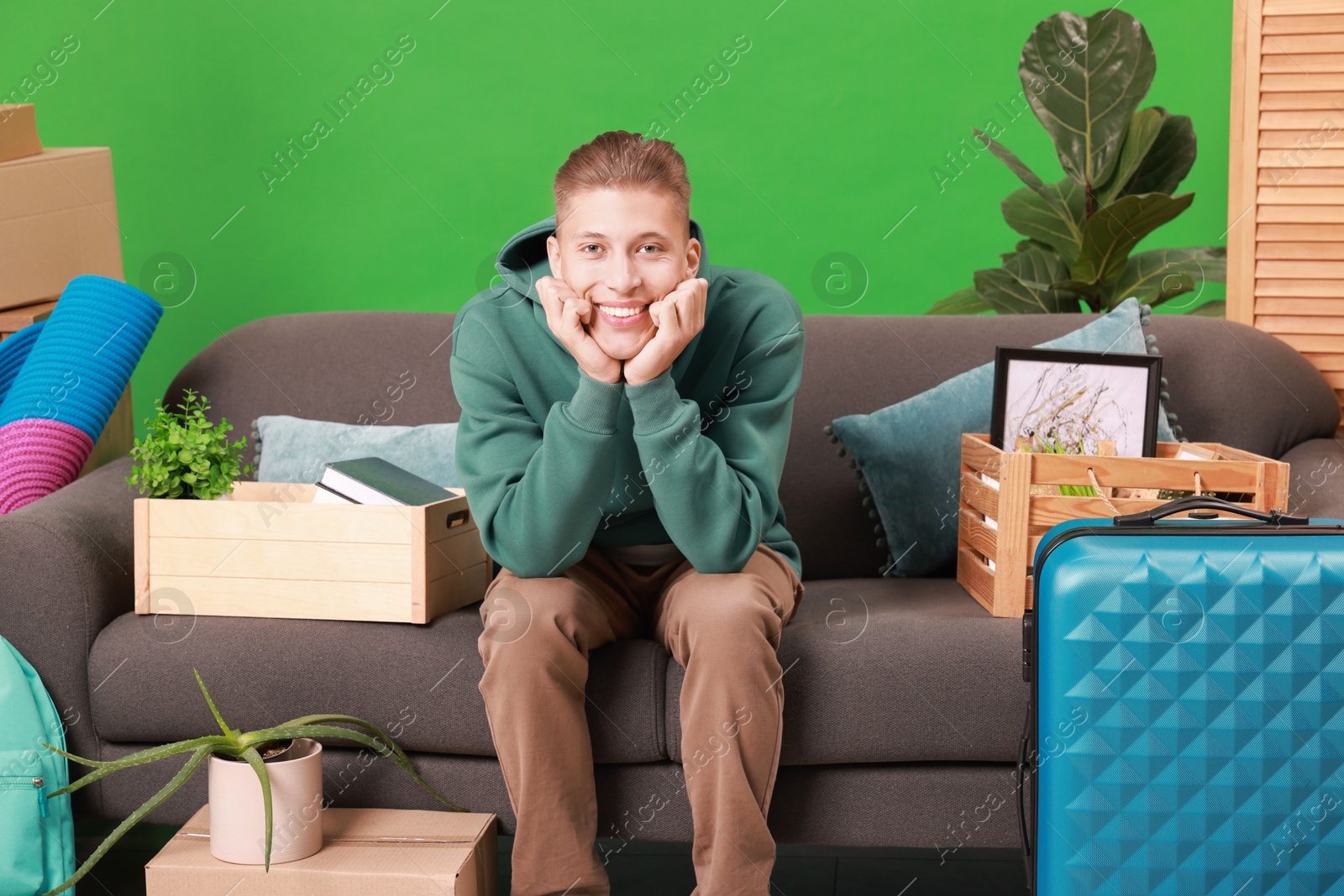 Photo of Happy man with different stuff in new apartment. Housewarming party