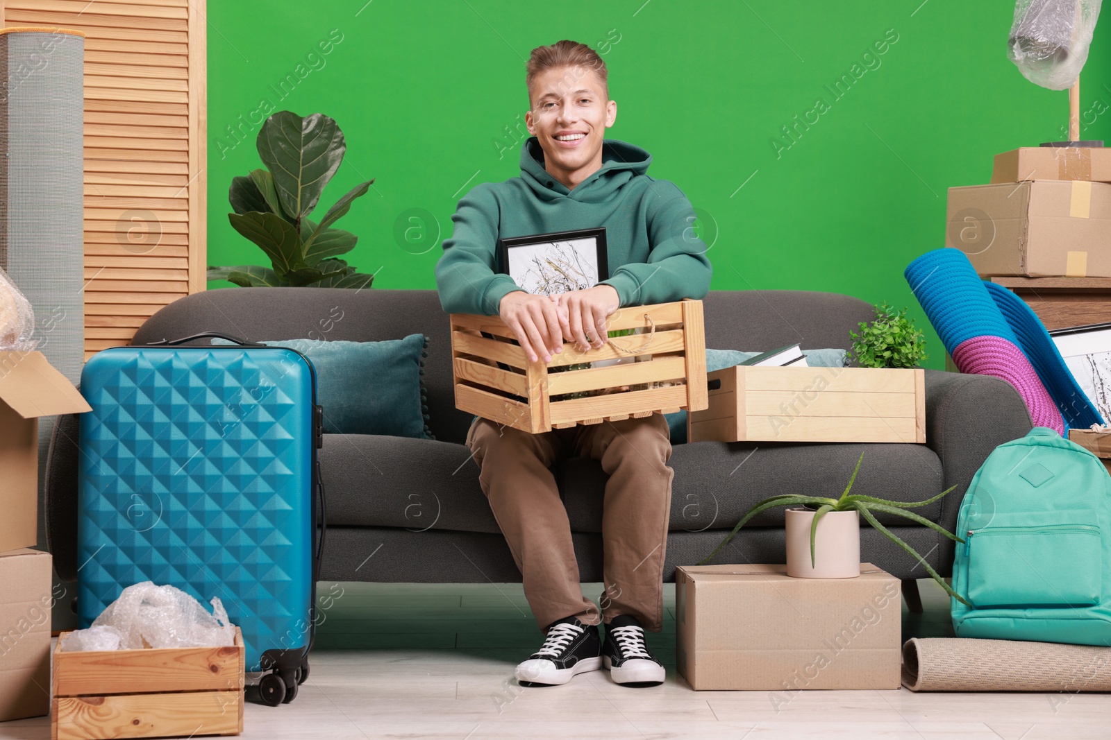 Photo of Happy man with different stuff in new apartment. Housewarming party