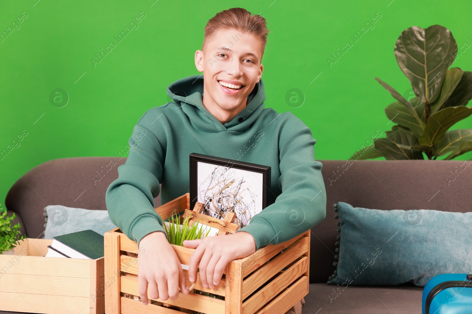 Photo of Happy man with different stuff in new apartment. Housewarming party