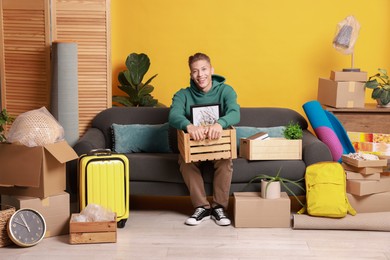 Photo of Happy man with different stuff in new apartment. Housewarming party