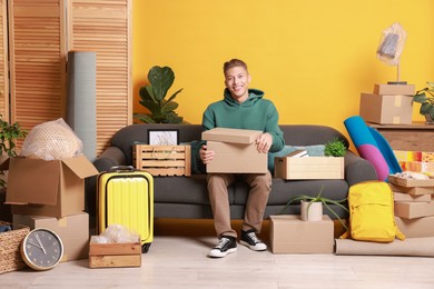 Photo of Happy man with different stuff in new apartment. Housewarming party