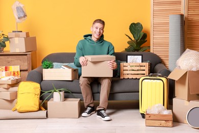 Photo of Happy man with different stuff in new apartment. Housewarming party