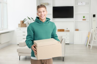 Photo of Happy man with moving boxes in new apartment. Housewarming party