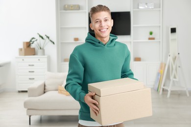 Photo of Happy man with moving boxes in new apartment. Housewarming party