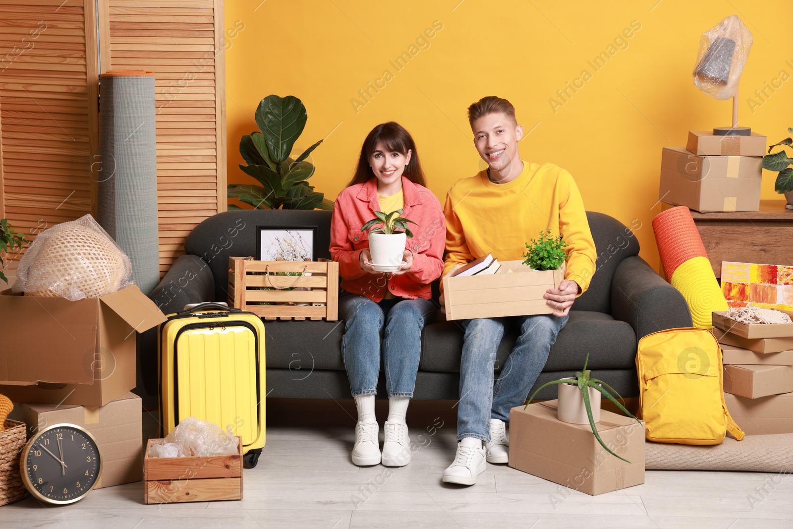 Photo of Happy couple with different stuff in new apartment. Housewarming party