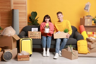 Photo of Happy couple with different stuff in new apartment. Housewarming party