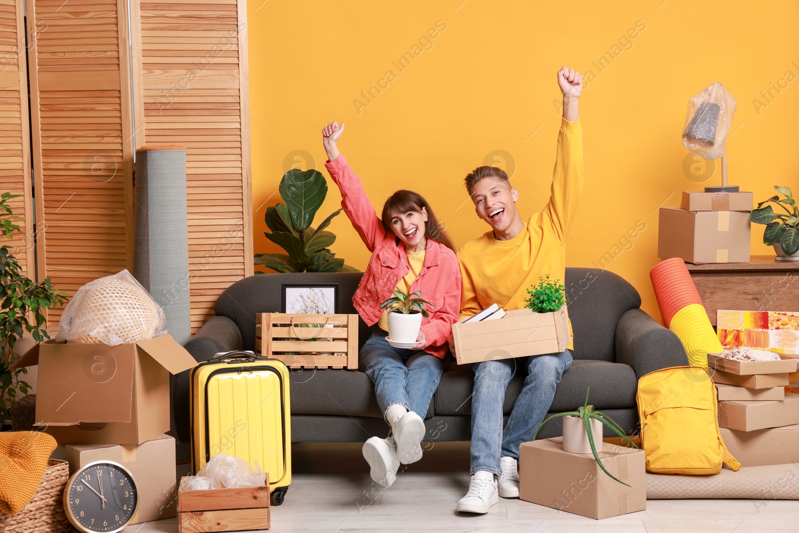 Photo of Happy couple with different stuff in new apartment. Housewarming party