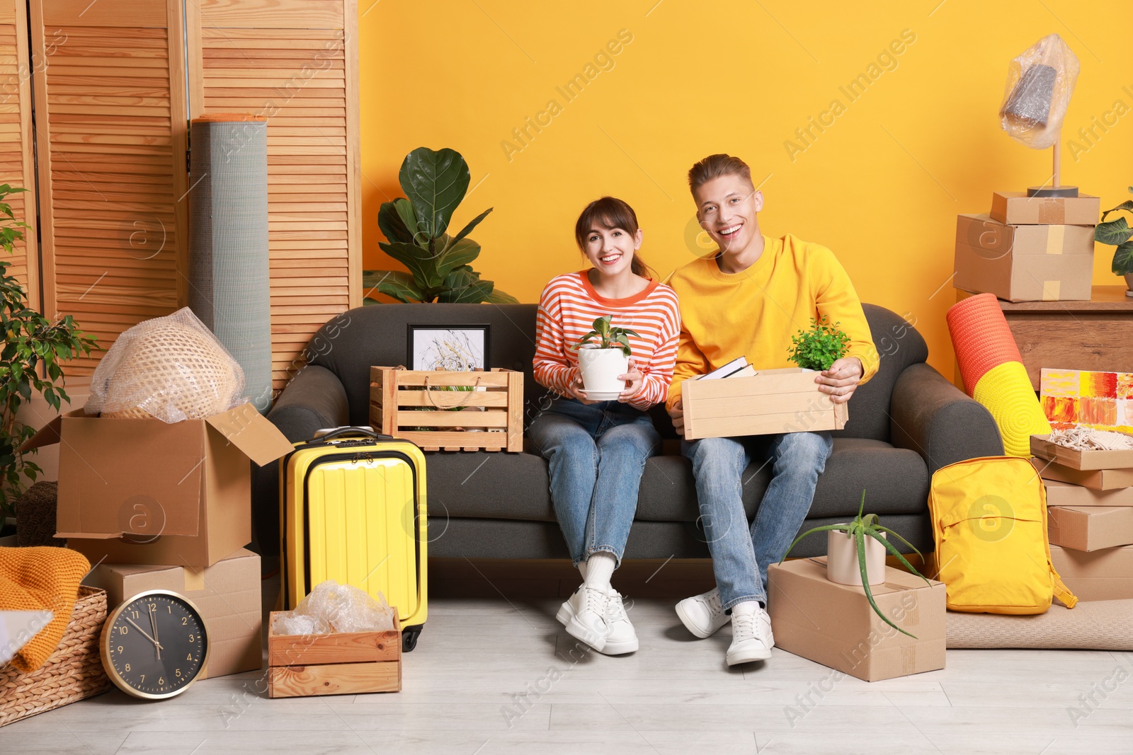 Photo of Happy couple with different stuff in new apartment. Housewarming party