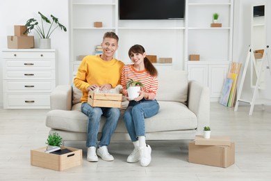 Photo of Happy couple with different stuff in new apartment. Housewarming party