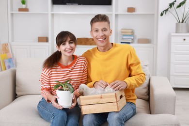 Photo of Happy couple with different stuff in new apartment. Housewarming party