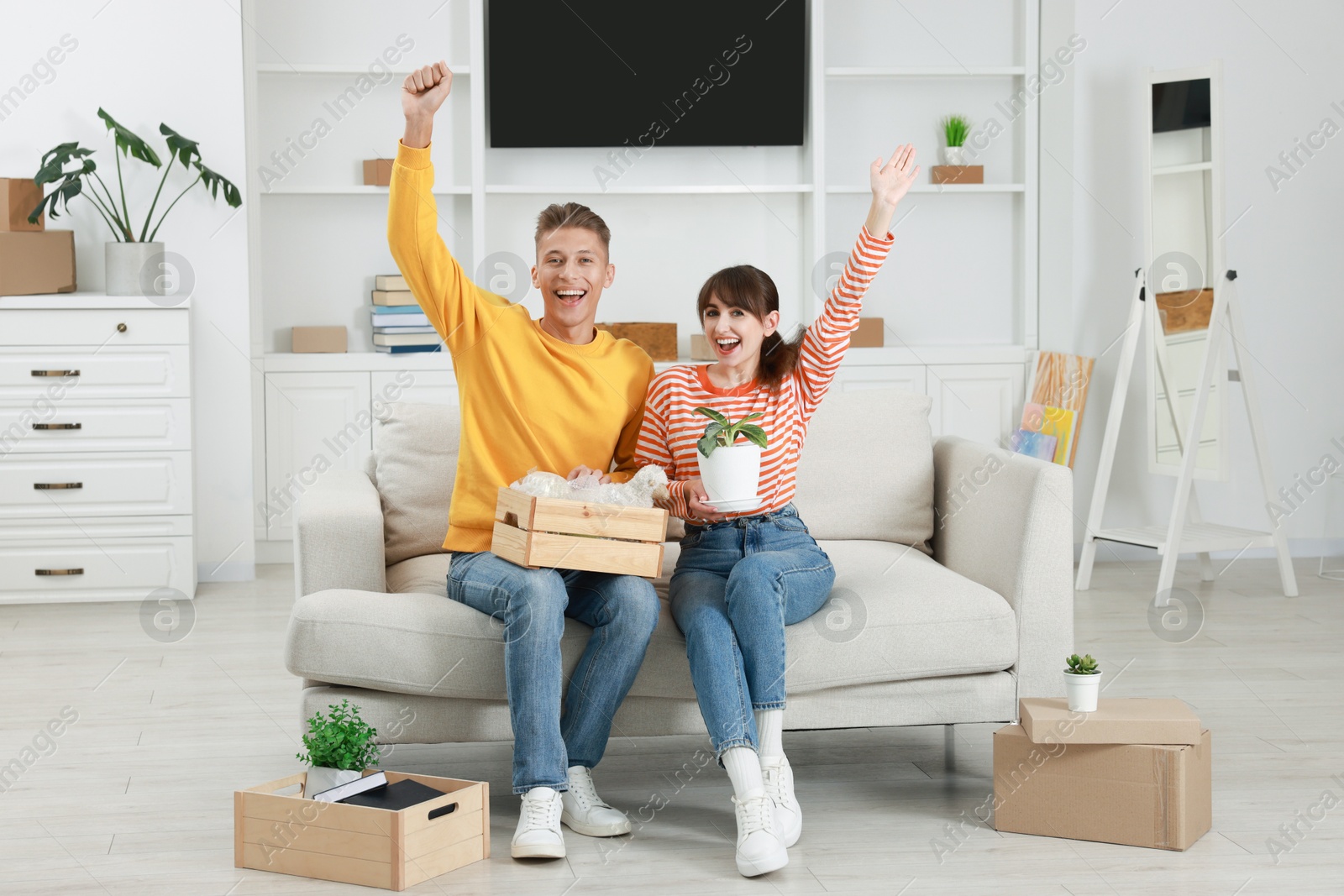 Photo of Happy couple with different stuff in new apartment. Housewarming party