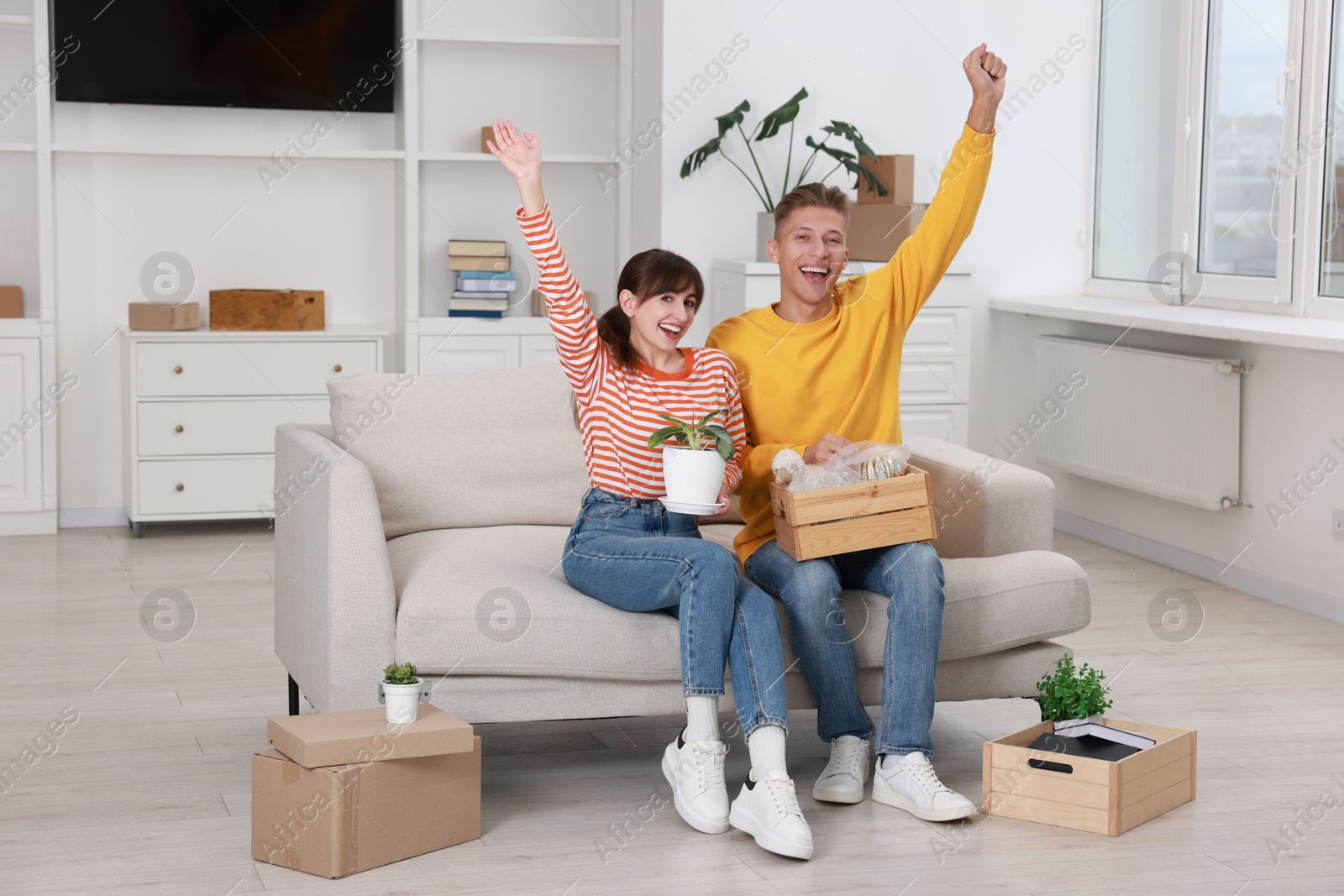 Photo of Happy couple with different stuff in new apartment. Housewarming party