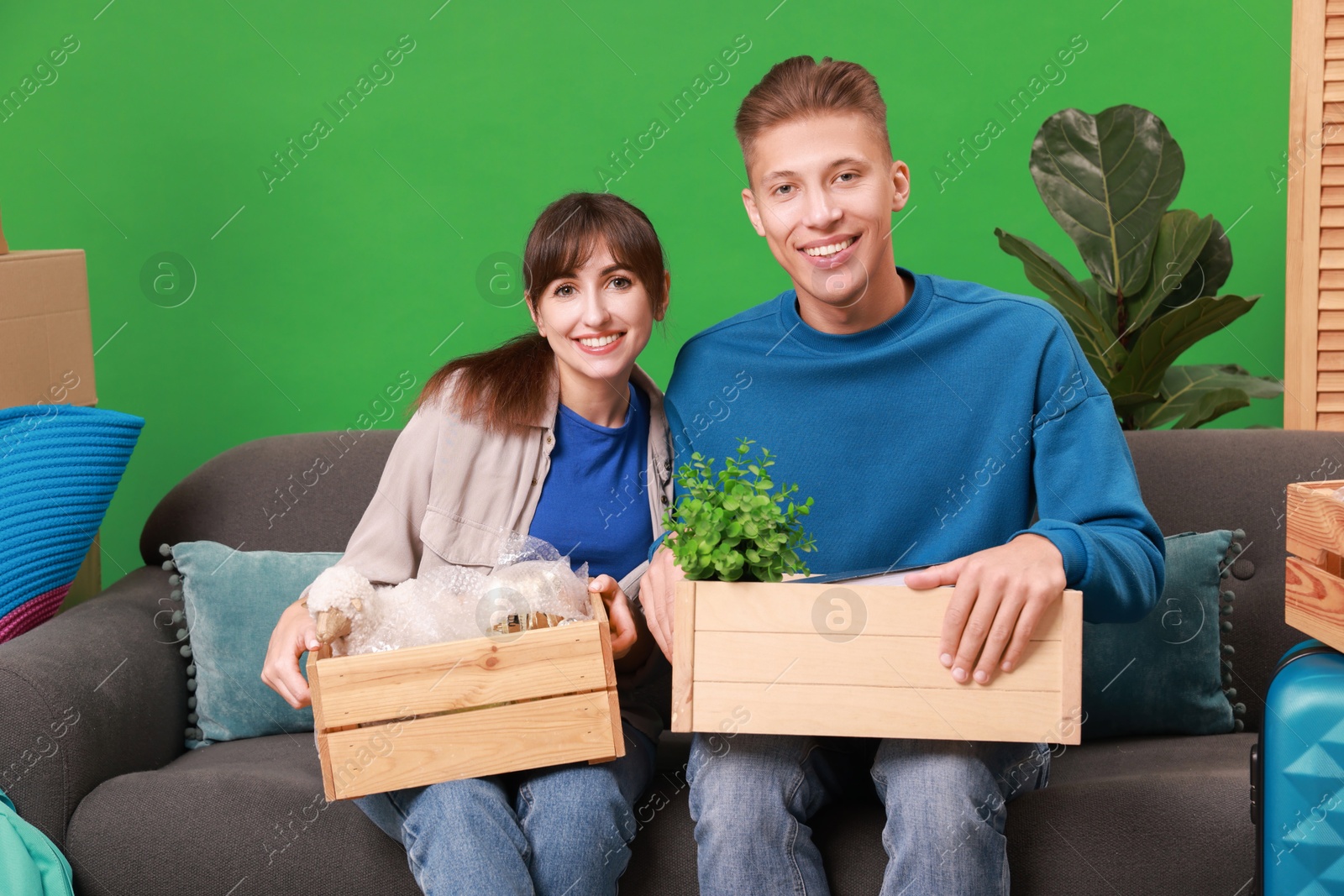 Photo of Happy couple with different stuff in new apartment. Housewarming party