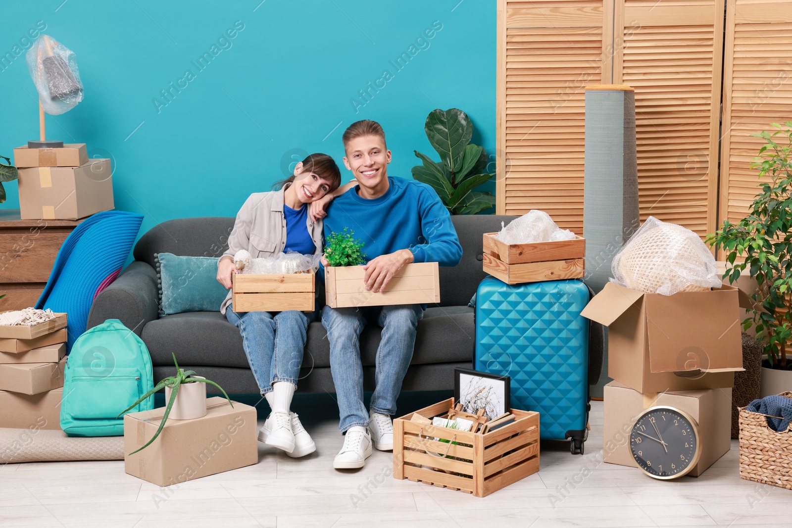 Photo of Happy couple with different stuff in new apartment. Housewarming party