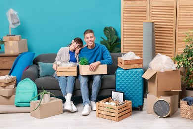 Photo of Happy couple with different stuff in new apartment. Housewarming party