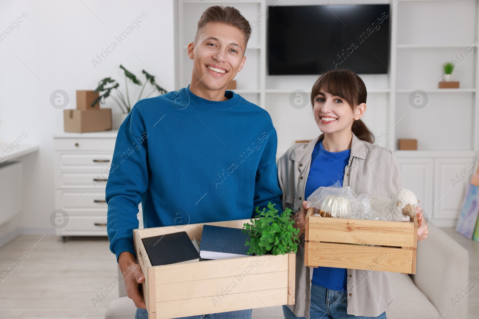 Photo of Happy couple with different stuff in new apartment. Housewarming party