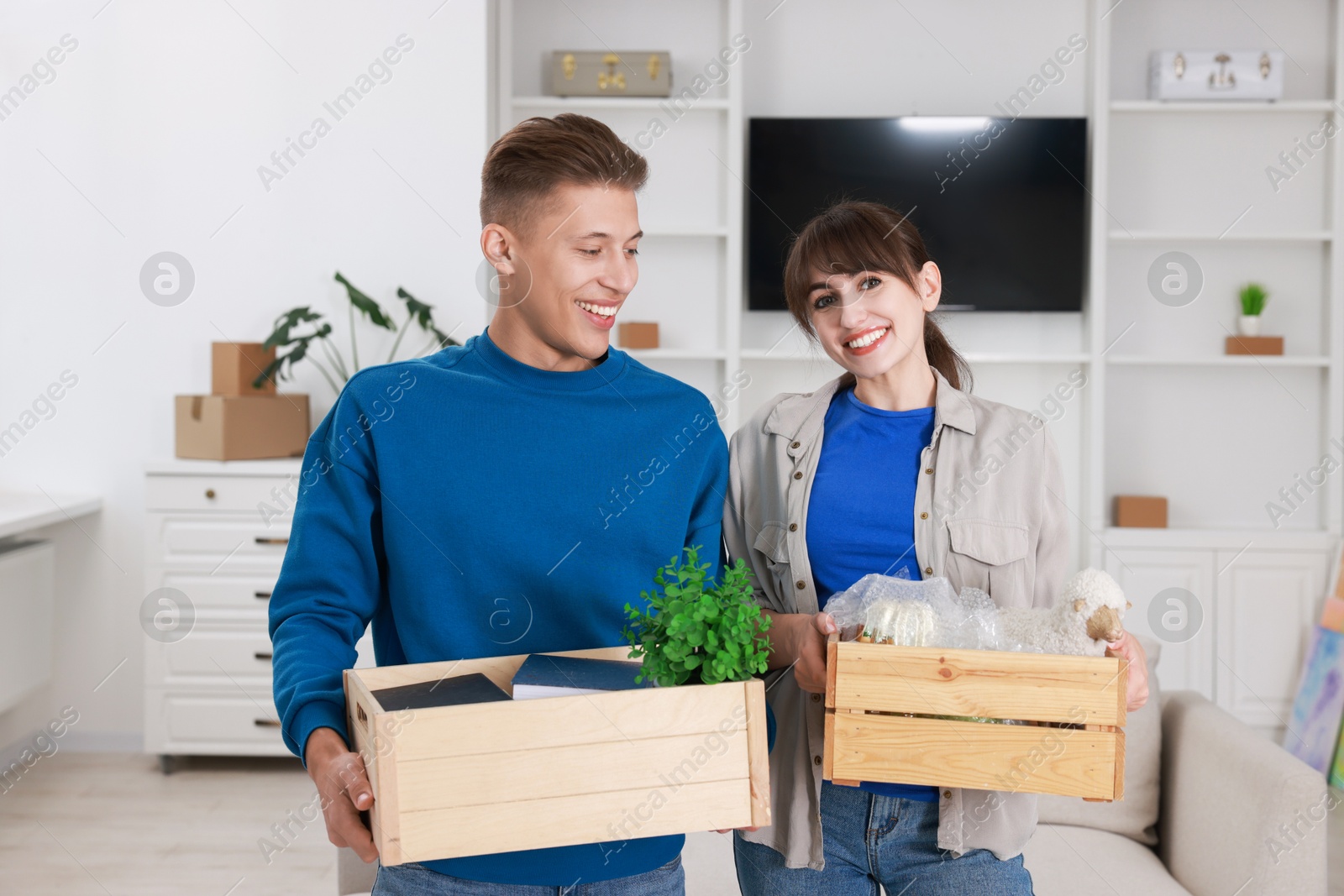 Photo of Happy couple with different stuff in new apartment. Housewarming party