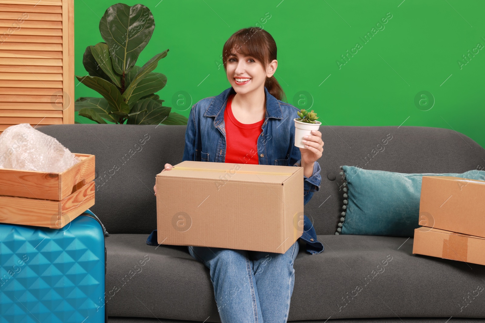 Photo of Happy woman with different stuff in new apartment. Housewarming party