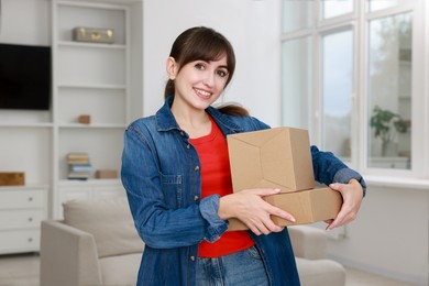 Photo of Happy woman with moving boxes in new apartment. Housewarming party