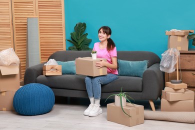 Photo of Happy woman with moving boxes in new apartment. Housewarming party