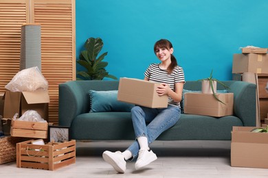 Photo of Happy woman with moving boxes in new apartment. Housewarming party