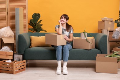 Happy woman with moving boxes in new apartment. Housewarming party