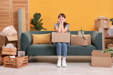 Happy woman with moving boxes in new apartment. Housewarming party