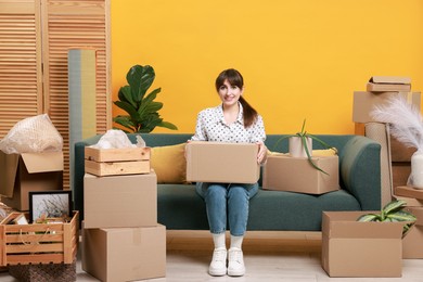 Happy woman with moving boxes in new apartment. Housewarming party