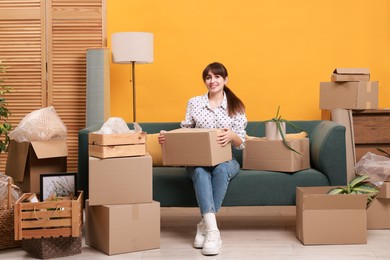 Photo of Happy woman with moving boxes in new apartment. Housewarming party