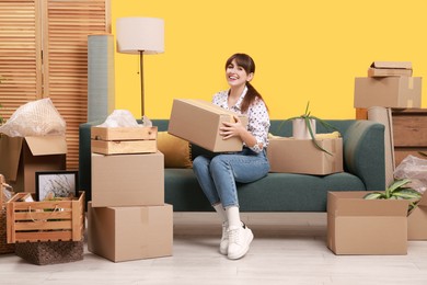 Photo of Happy woman with moving boxes in new apartment. Housewarming party