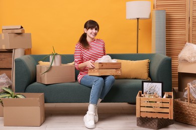 Photo of Happy woman with moving boxes in new apartment. Housewarming party