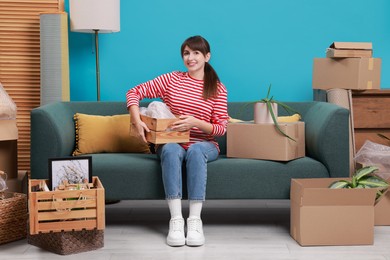 Photo of Happy woman with moving boxes in new apartment. Housewarming party