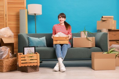 Photo of Happy woman with moving boxes in new apartment. Housewarming party