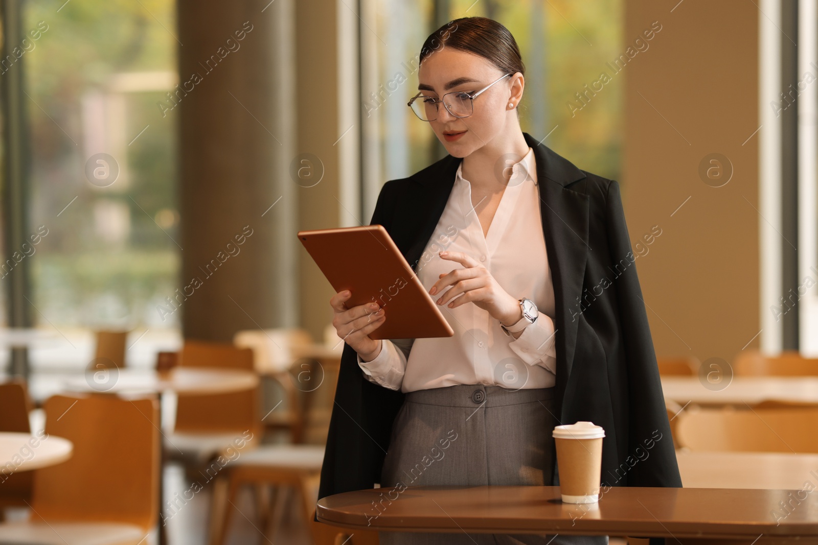 Photo of Woman in stylish formal suit with tablet indoors