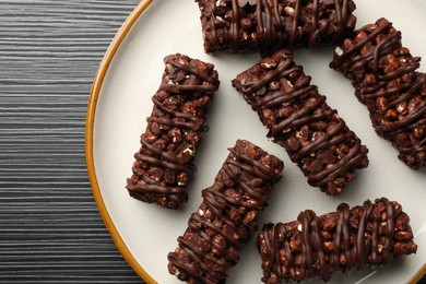 Delicious chocolate puffed rice bars on dark gray wooden table, top view