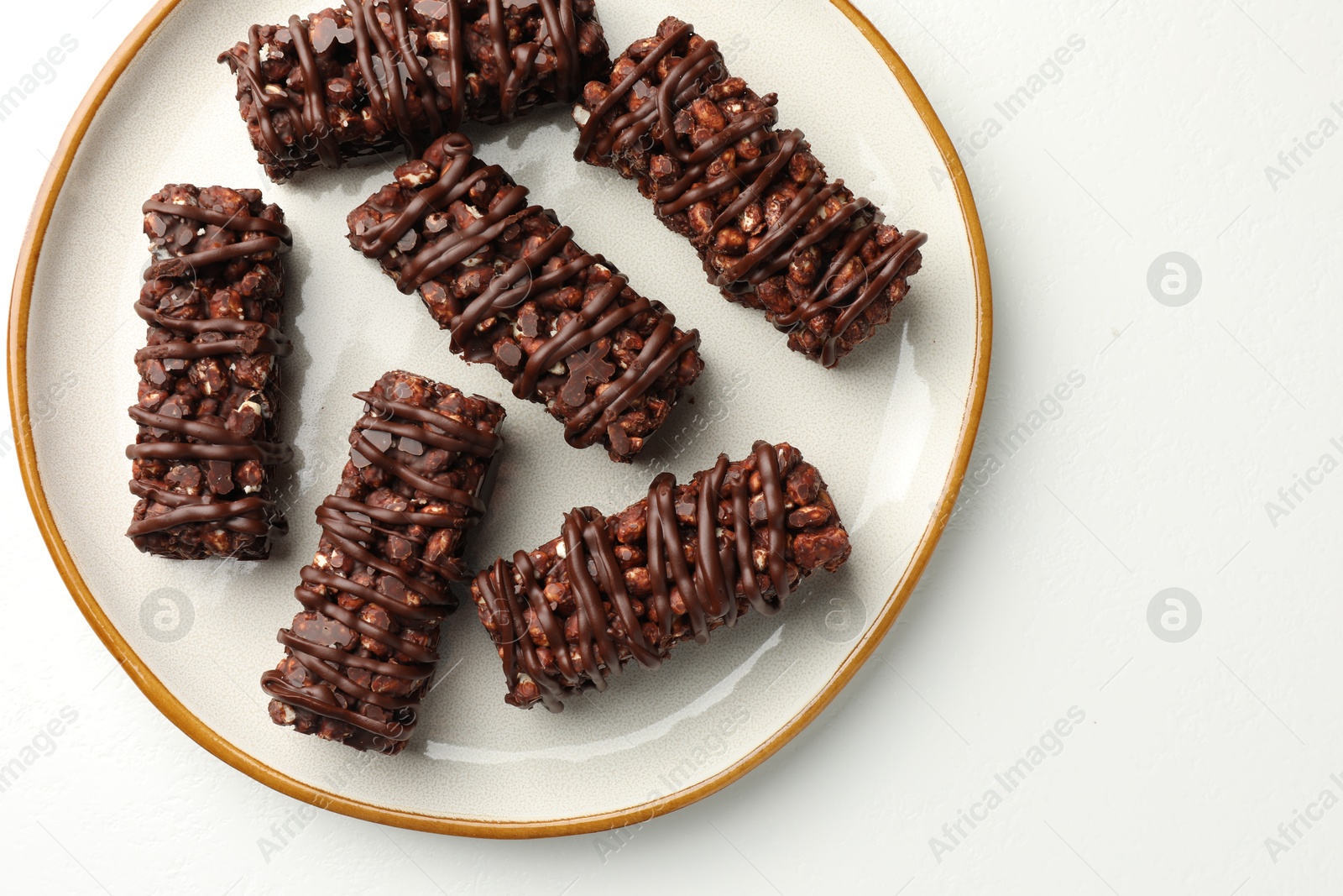 Photo of Delicious chocolate puffed rice bars on white table, top view. Space for text